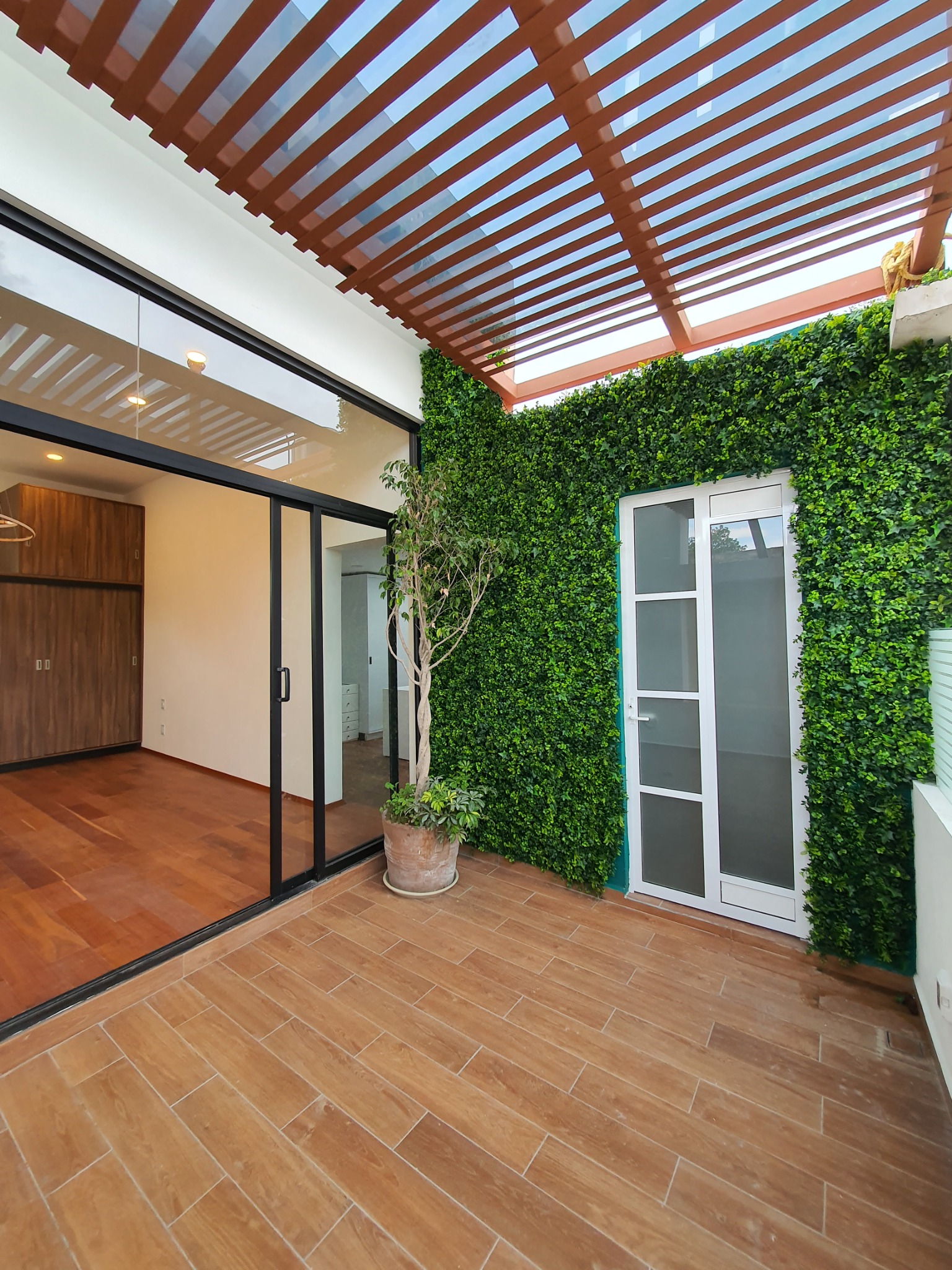 Casa para Navidad — terraza con pérgola y muro verde